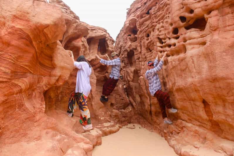 Rock climbers navigating the red rock formations in Dahab Canyon duri egypt dahab blue hole, jeep safari from sharm el sheikh