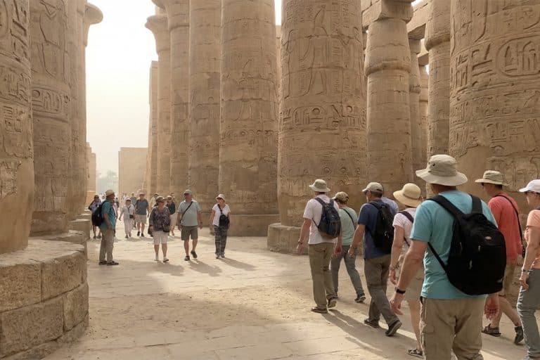 Visitors walking through the columns of Luxor Temple luxor tours, luxor to aswan