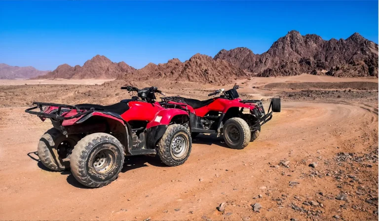 Two red ATVs ready atv tour near me, atv adventure tours