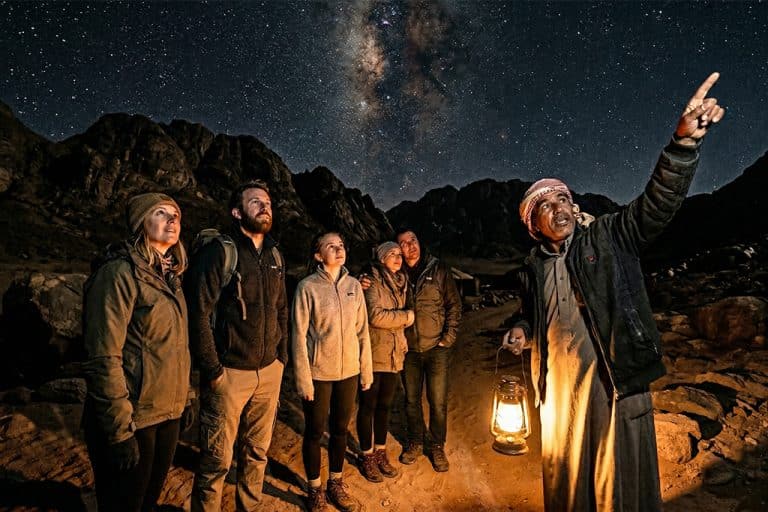 Group enjoying a while luxury dinner set, stargazing tour joshua tree