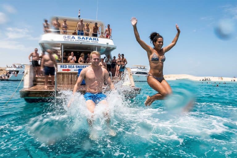 Two people jumping into the water snorkel rental near me, snorkeling tours